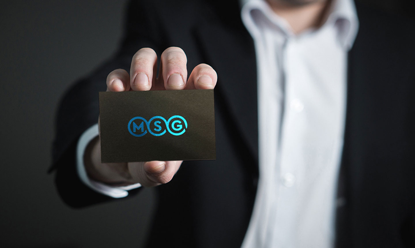 Man in suite showing MSG business card
